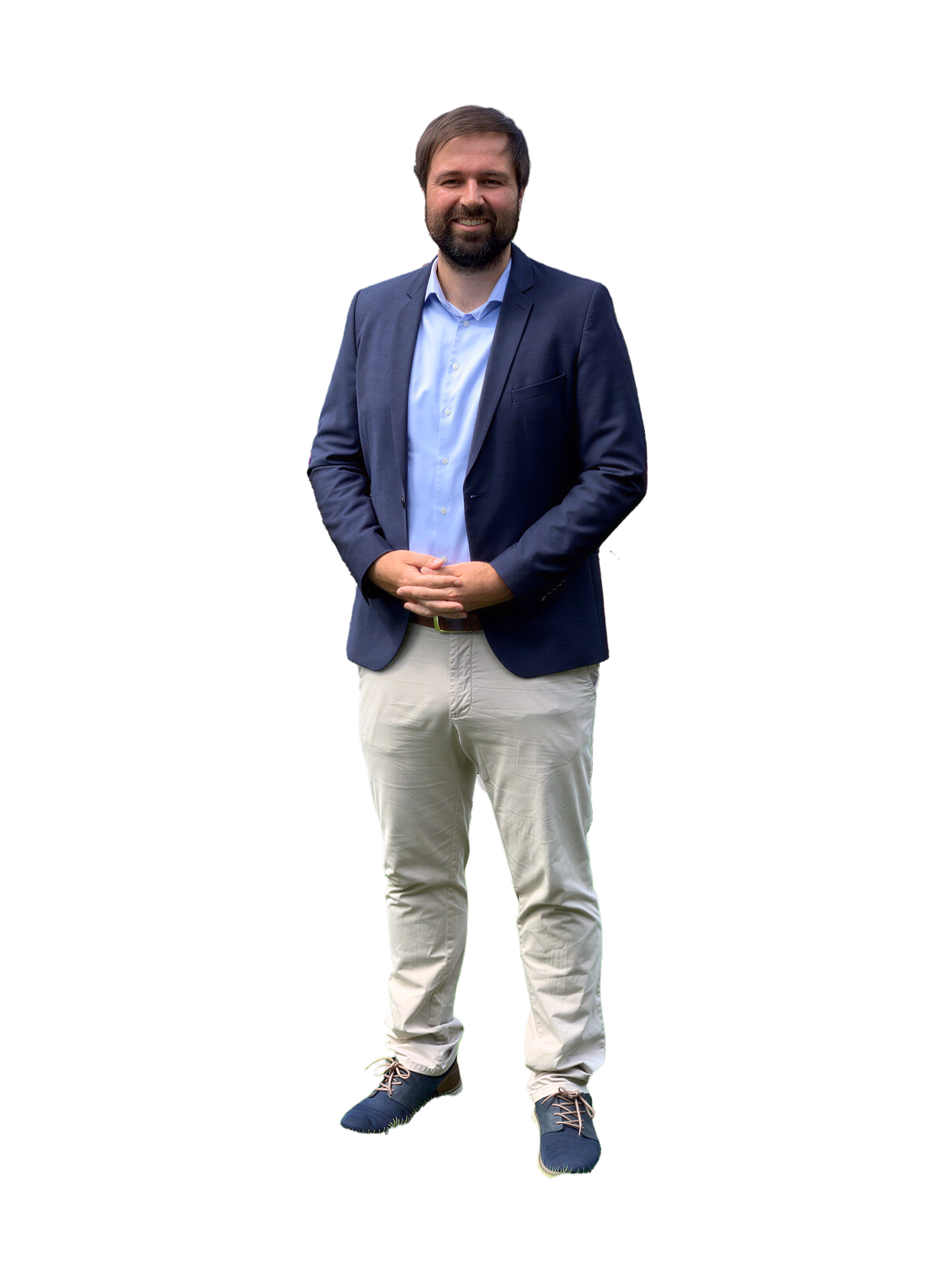 Yannick Berthelsen im dunkelblauen Sakko und in heller Hose